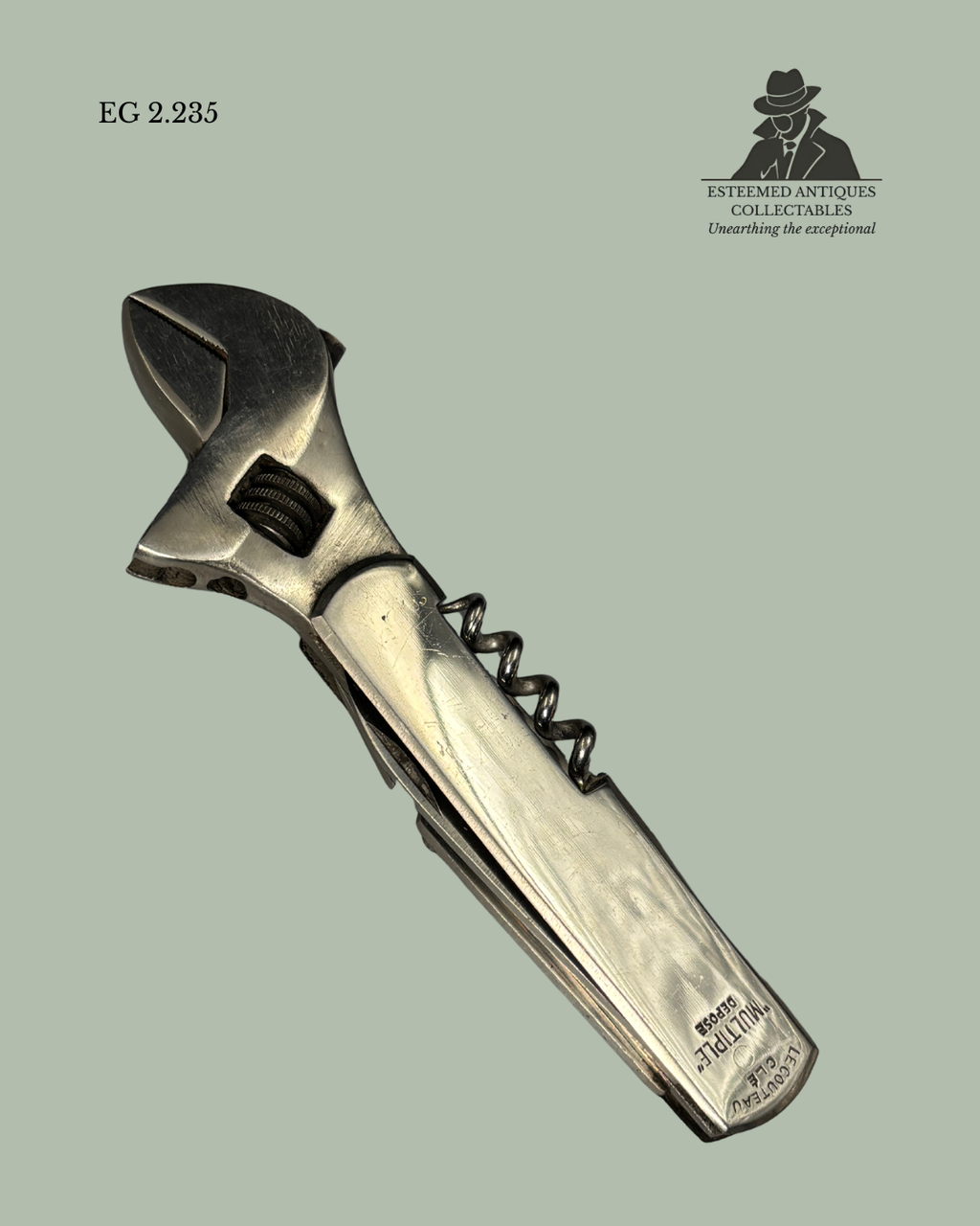 Wrench-shaped corkscrew on a light green background with 'Estremoz Antiques Collectables' branding.