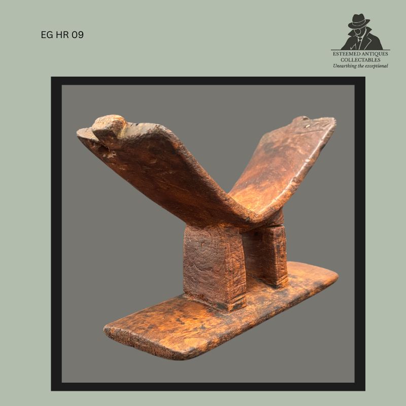 Kuba carved hardwood headrest from the Democratic Republic of the Congo, featuring a V-shaped neck support raised on two rectangular pillars above an elongated base, with a rich worn patina from use and age, collected from the Egon Guenther family collection.