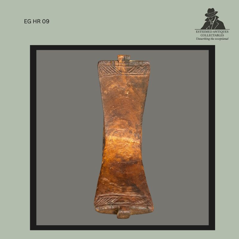Rear view of a Kuba carved wooden headrest from the Democratic Republic of the Congo, featuring a gently waisted support with geometric carved border decoration at both ends, polished surface patina from use, and traditional construction associated with personal neck supports used to preserve elaborate coiffure styles.