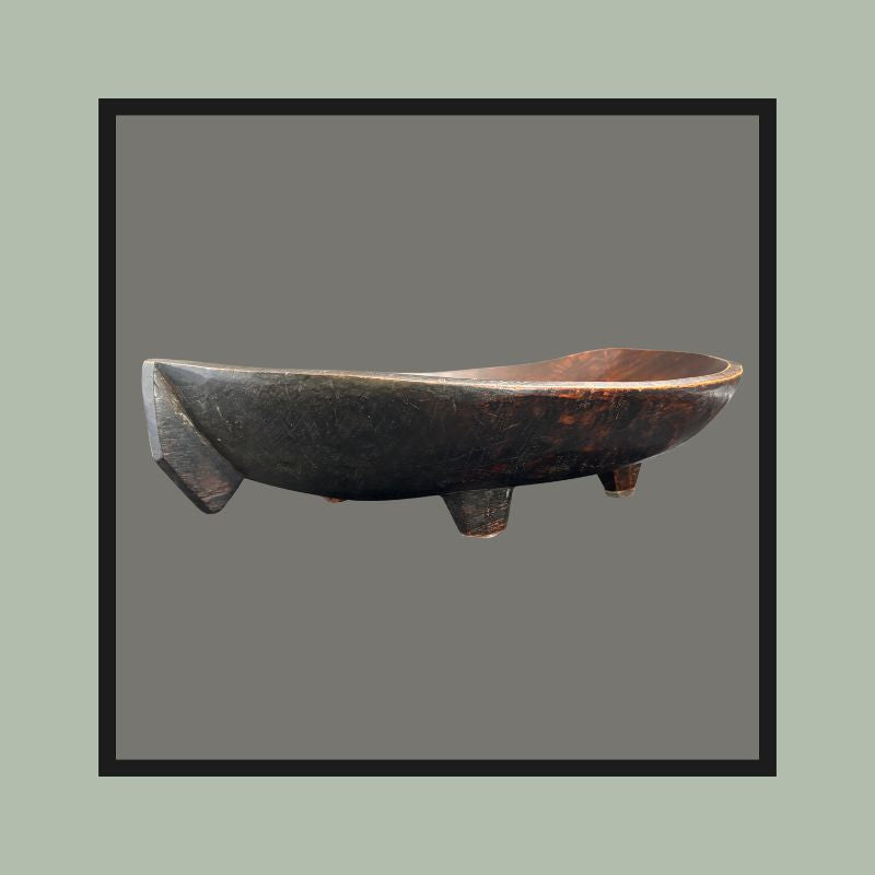 Four-legged hardwood bowl with opposing lug handles, carved from a single block, South Africa, 20th century.