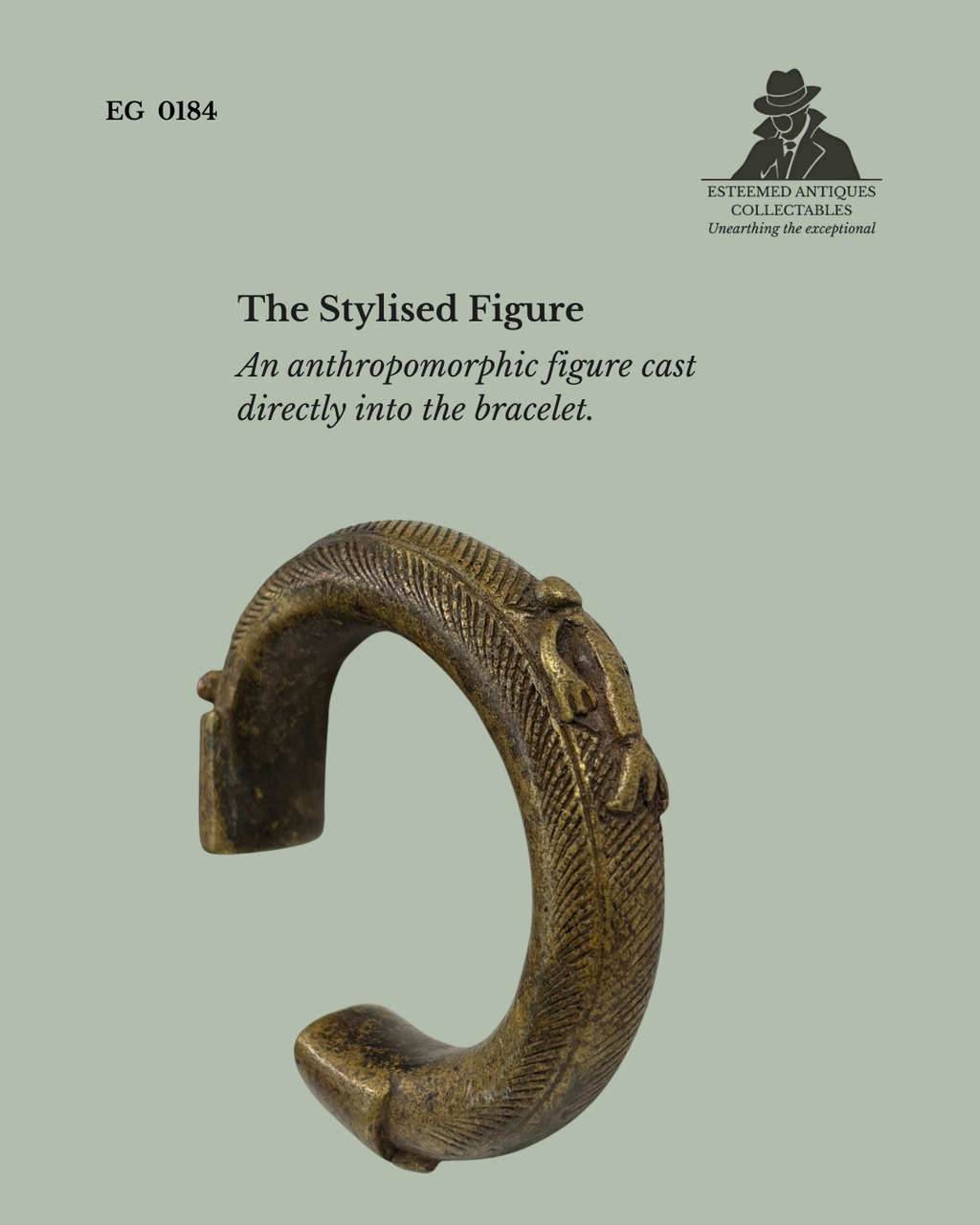 Detail view of a West African Akan cast brass manilla currency bracelet showing a stylised anthropomorphic figure integrated into the bracelet by the lost-wax casting process, with finely incised surface decoration.