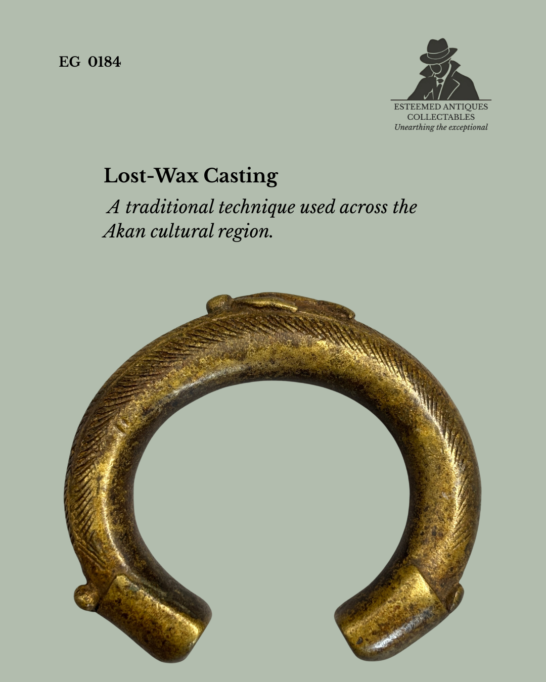 Front view of an Akan lost-wax cast brass manilla currency bracelet with finely incised diagonal surface decoration, displayed against a neutral background. Traditional West African currency and prestige object from the Egon Guenther Collection.