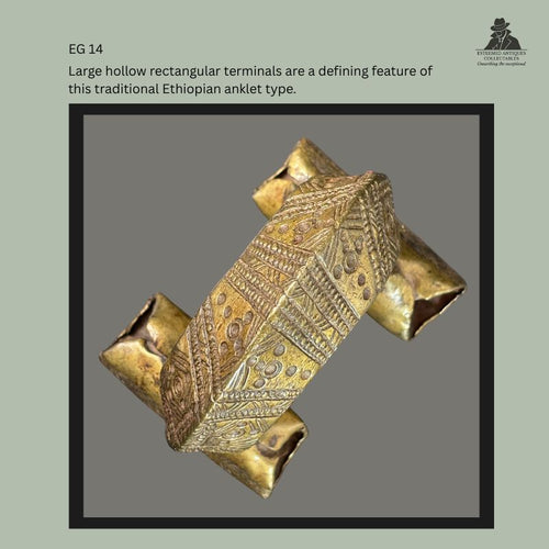 Traditional Amhara-Tigray brass anklet from Ethiopia showing the characteristic hollow rectangular terminals and finely engraved geometric decoration across the broad arched band, from the Egon Guenther Collection.