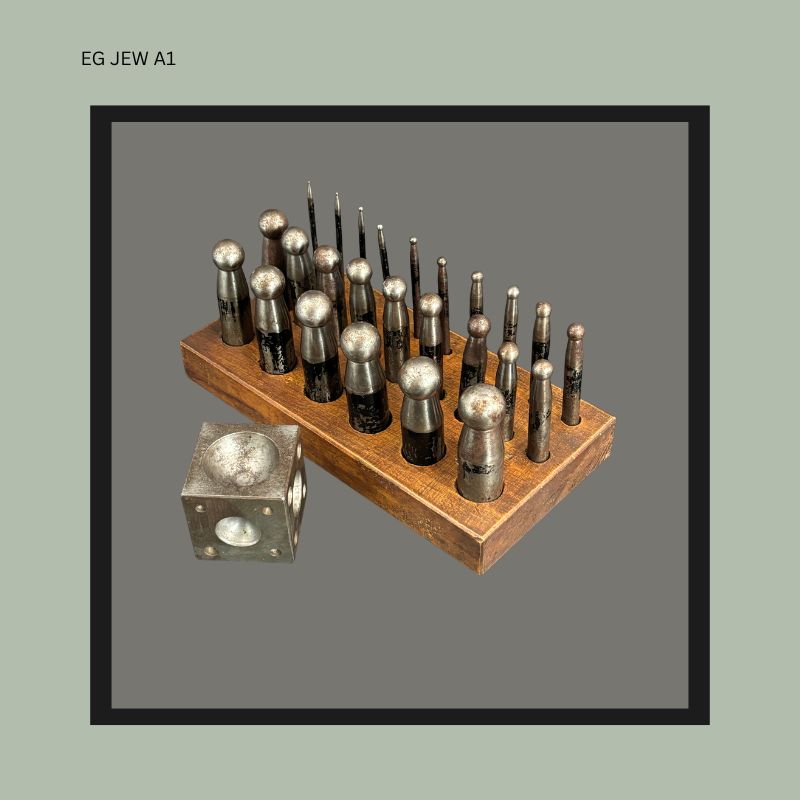 Antique German jewellers dapping punch set with doming block, comprising graduated machined steel punches displayed in a fitted wooden stand, from the Egon Guenther family jewellery tool collection.