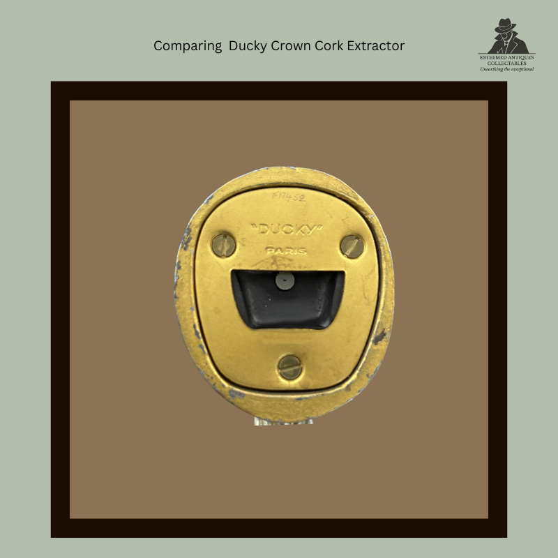 Base view of the later Ducky Paris duck-head crown cork extractor, showing the brass underside plate marked “DUCKY” PARIS, three fixing screws and the rectangular crown cork extraction slot.