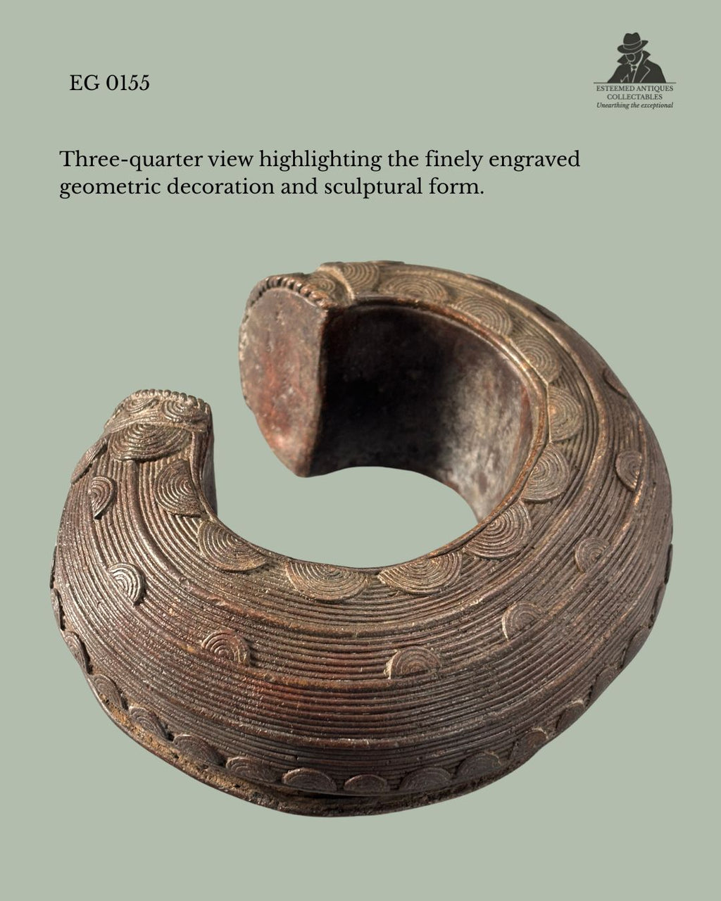 Three-quarter view of a Baoulé cast brass anklet from Côte d’Ivoire, showing finely engraved concentric geometric decoration, sculptural open-cuff form, and rich aged patina, from the Egon Guenther Collection.
