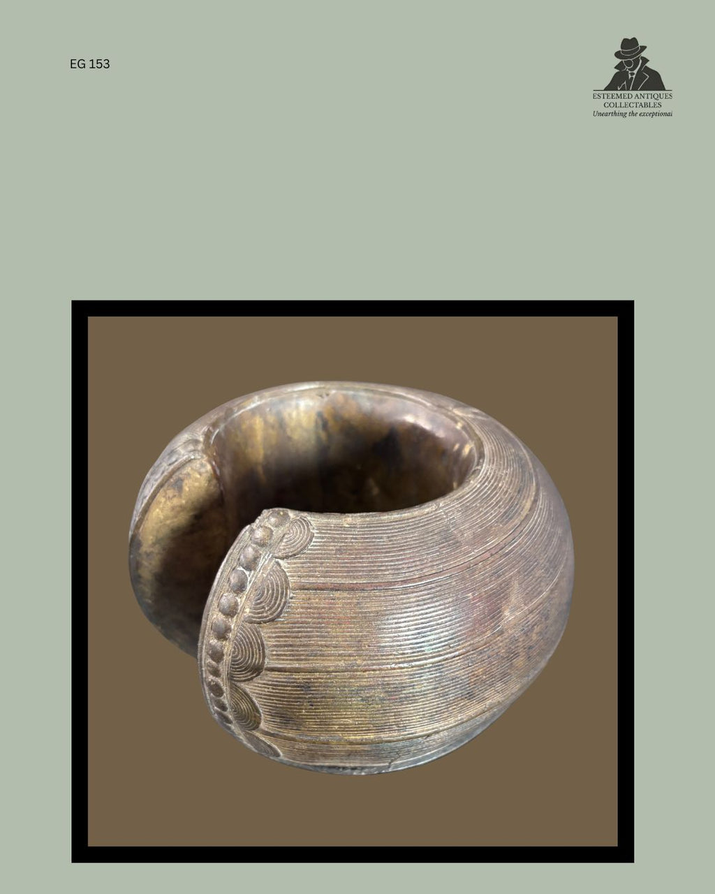 Detail view of a Baoulé lost-wax cast brass anklet from Côte d'Ivoire, showing finely incised concentric line decoration, raised border ornament and the substantial open-cuff form, from the Egon Guenther Collection.
