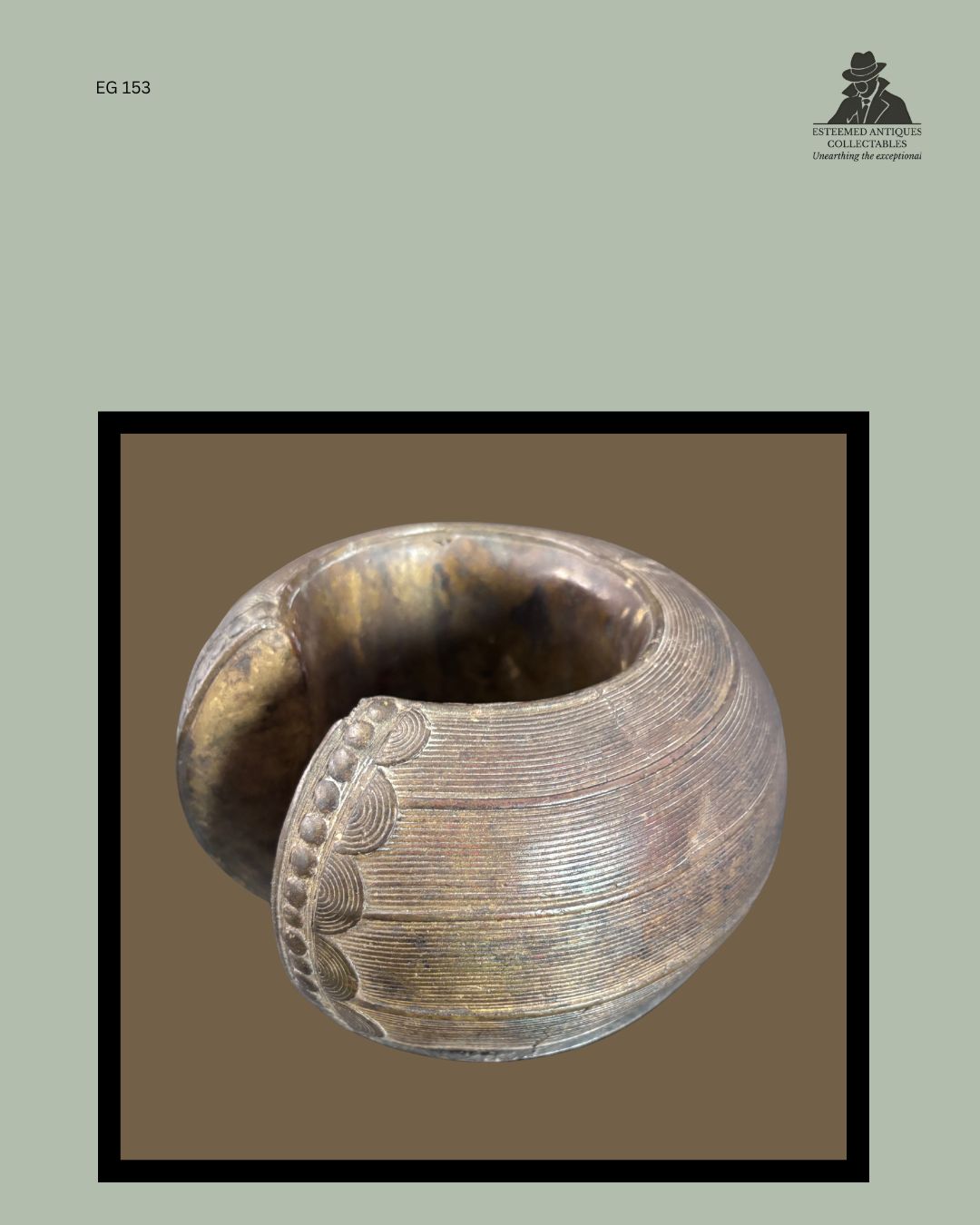 Detail view of a Baoulé lost-wax cast brass anklet from Côte d'Ivoire, showing finely incised concentric line decoration, raised border ornament and the substantial open-cuff form, from the Egon Guenther Collection.