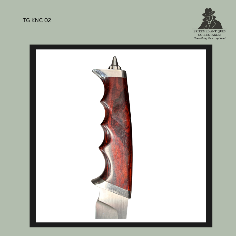 Close-up side view of the hand-carved polished hardwood handle on a handmade Burger hunting knife, showing deep ergonomic finger grooves, brushed metal bolsters, and the exposed tang construction by a South African knifemaker.