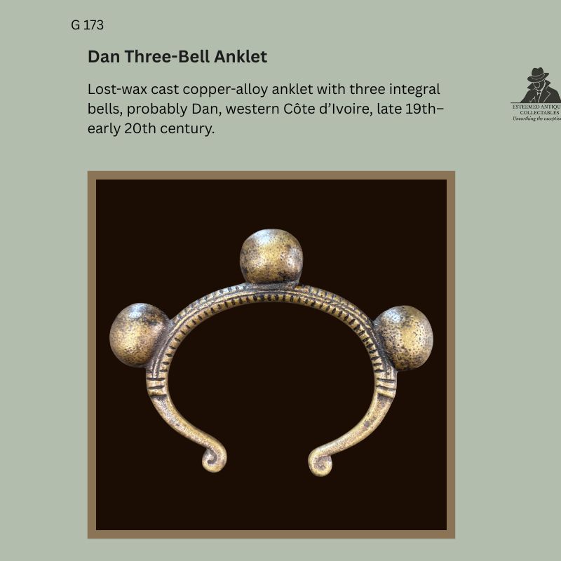 Dan three-bell lost-wax cast copper-alloy anklet from western Côte d’Ivoire, late 19th to early 20th century, with three integral spherical bells and ribbed penannular body, Egon Guenther Collection.