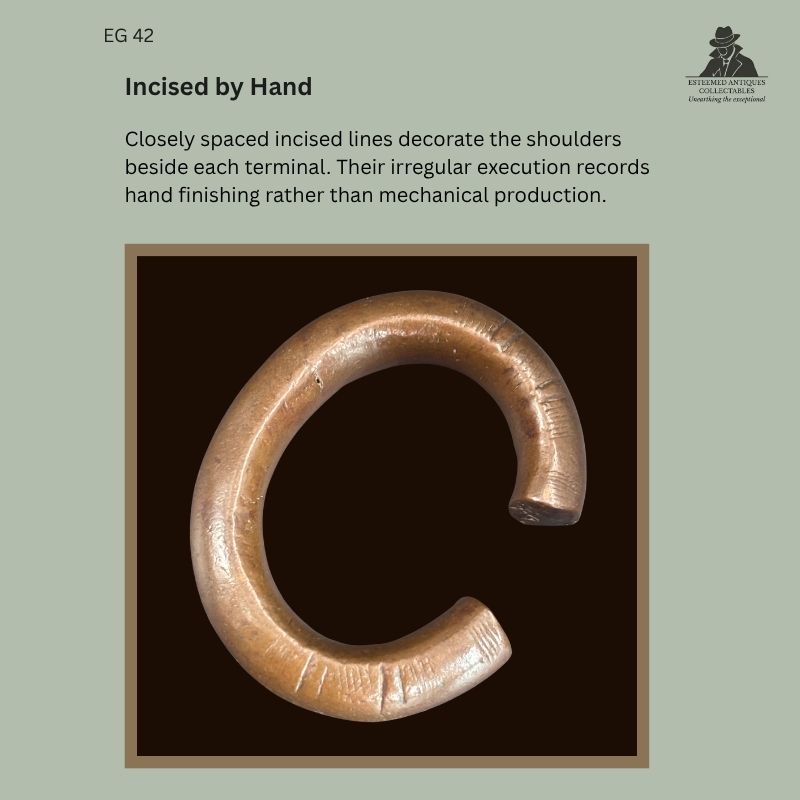 Catalogue panel showing EG 42, a West African copper-alloy penannular bracelet attributed to the Senufo, with irregular hand-incised lines visible beside the open terminals.