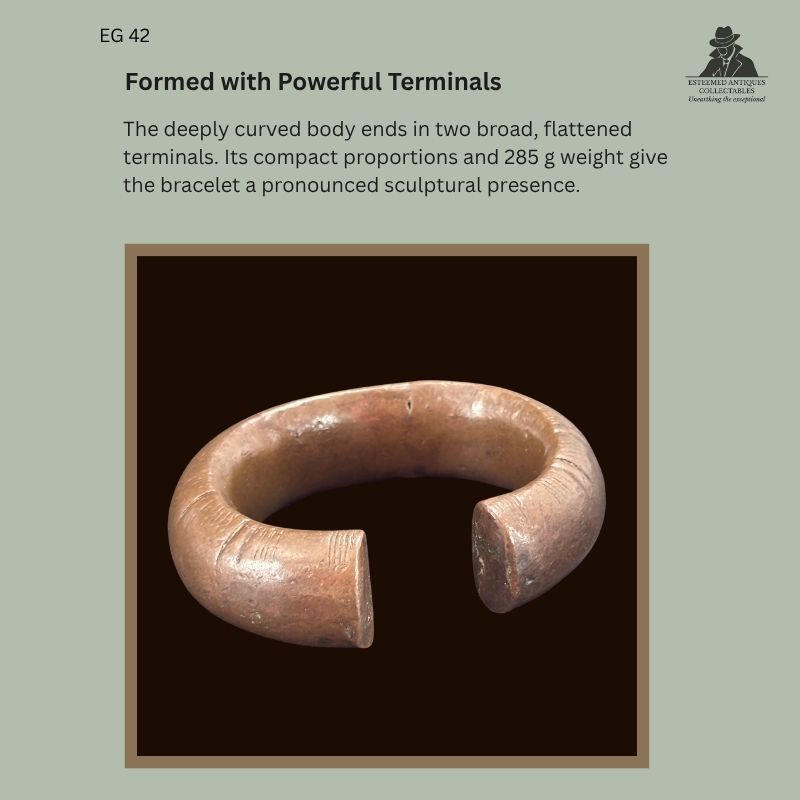 Catalogue panel showing EG 42, a cast West African copper-alloy penannular bracelet attributed to the Senufo, with a deeply curved body and broad flattened terminals.