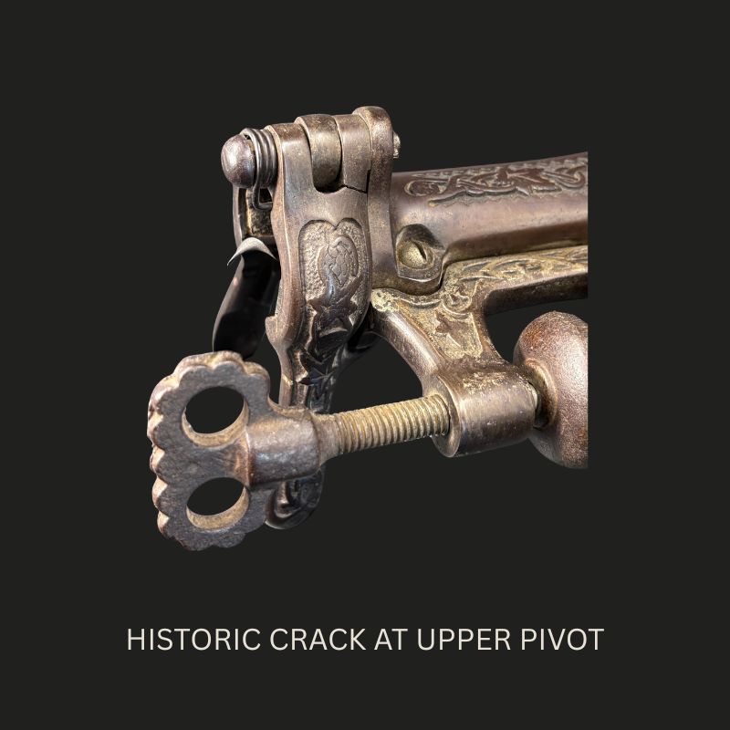 Close-up of the ornate cast-iron mechanism on a Farrow & Jackson Safety counter-mounted bar corkscrew, showing the historic structural crack beside the upper pivot.