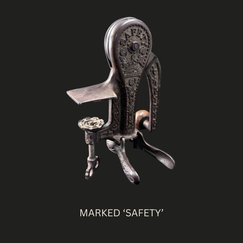 Reverse view of the Farrow & Jackson cast-iron counter-mounted bar corkscrew, showing the raised SAFETY mark, ornate relief decoration, lever-operated bottle grip and bench clamp.