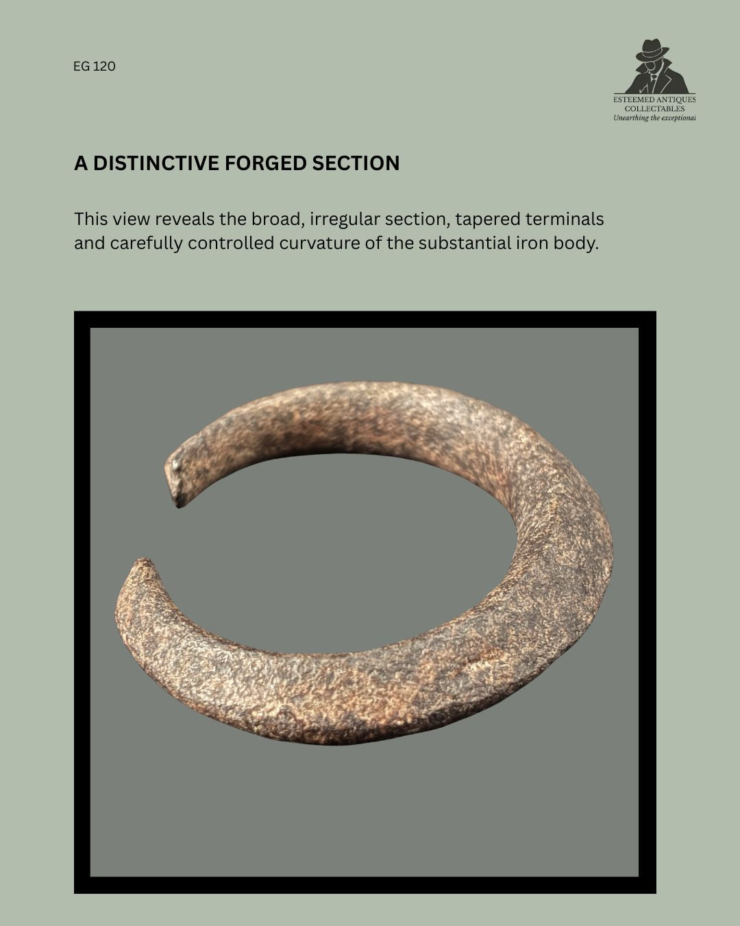 Angled view of a Nigerian forged iron manilla-form currency bracelet, EG 120, showing its broad irregular section, controlled curvature and tapered open terminals.