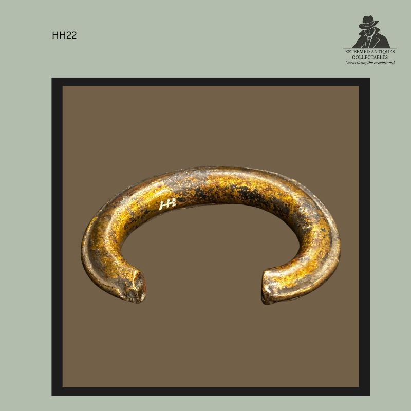 Close view of a West African cast brass currency bracelet showing the original white Hans Himmelheber inventory mark HH on the inner surface, documenting provenance from the Hans Himmelheber Collection to the Egon Guenther Collection and Thomas Guenther Collection, Netherlands.