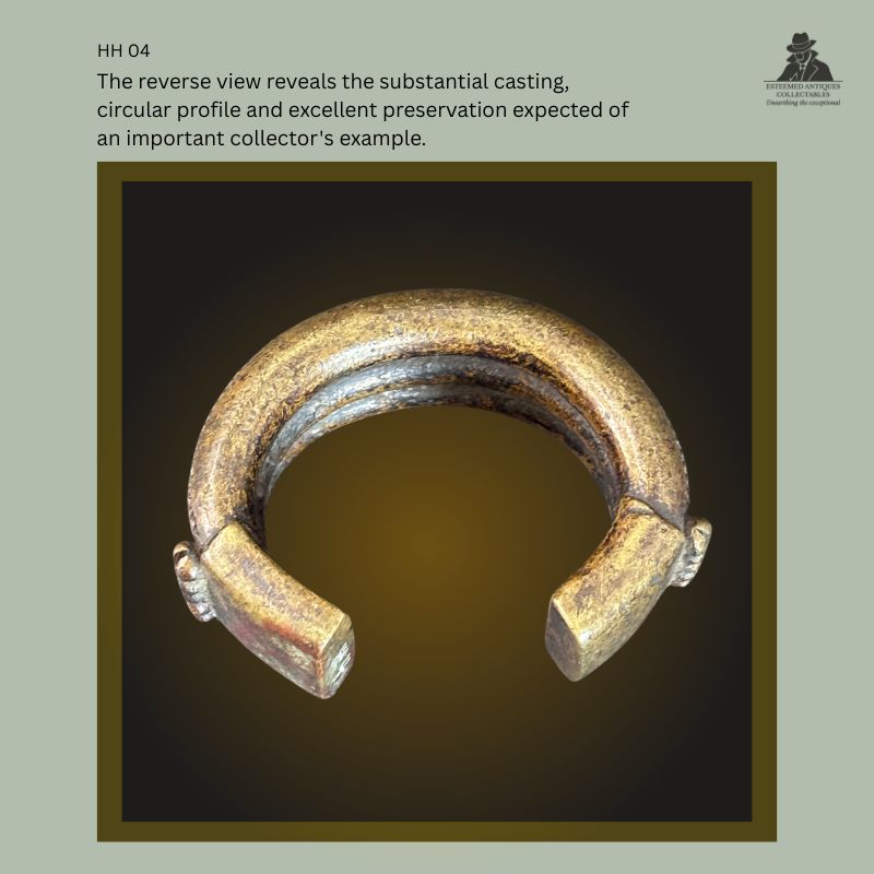 Rear view of a West African lost-wax cast brass manilla currency bracelet, showing its substantial circular cross-section, open terminals, casting seam, rich aged patina, and preserved surface from the Hans Himmelheber Collection, later the Egon Guenther Collection and Thomas Guenther Collection.