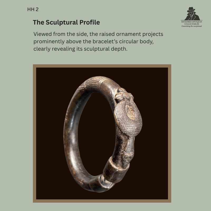 Side profile of the HH 2 West African zoomorphic copper-alloy bracelet, probably Senufo, showing the raised lost-wax-cast ornament and circular body from the Hans Himmelheber provenance collection.