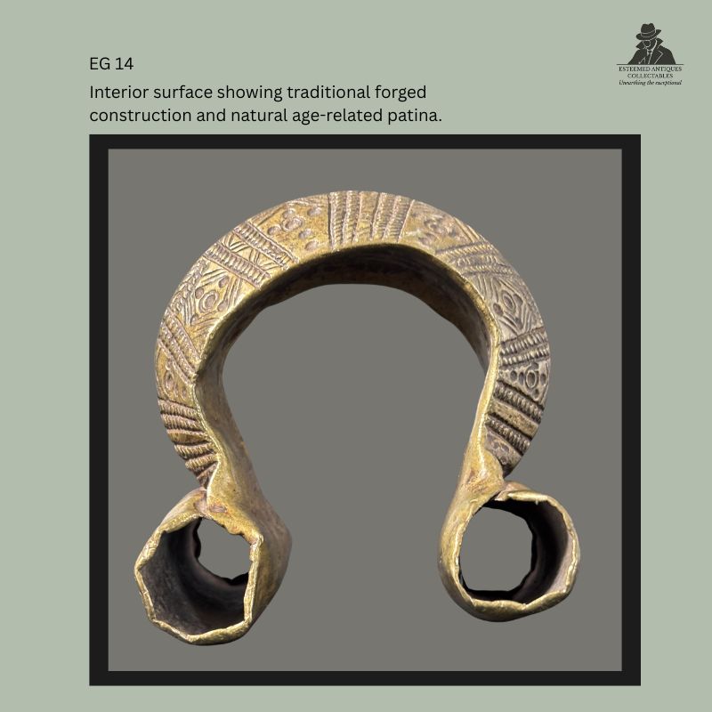 Interior reverse view of a cast brass Kasena Gurunsi anklet from Burkina Faso, showing the hollow forged construction, engraved geometric decoration across the outer band, open terminals, and naturally developed age-related patina, from the Egon Guenther Collection.
