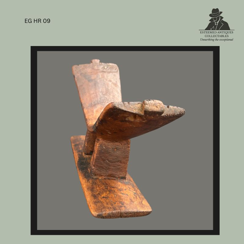 Kuba carved wooden headrest from the Democratic Republic of the Congo, hand-carved from a single piece of wood with a rectangular base, central support, projecting headrest platform and upright back element, showing aged surface wear and patina consistent with long use, Egon Guenther Collection.