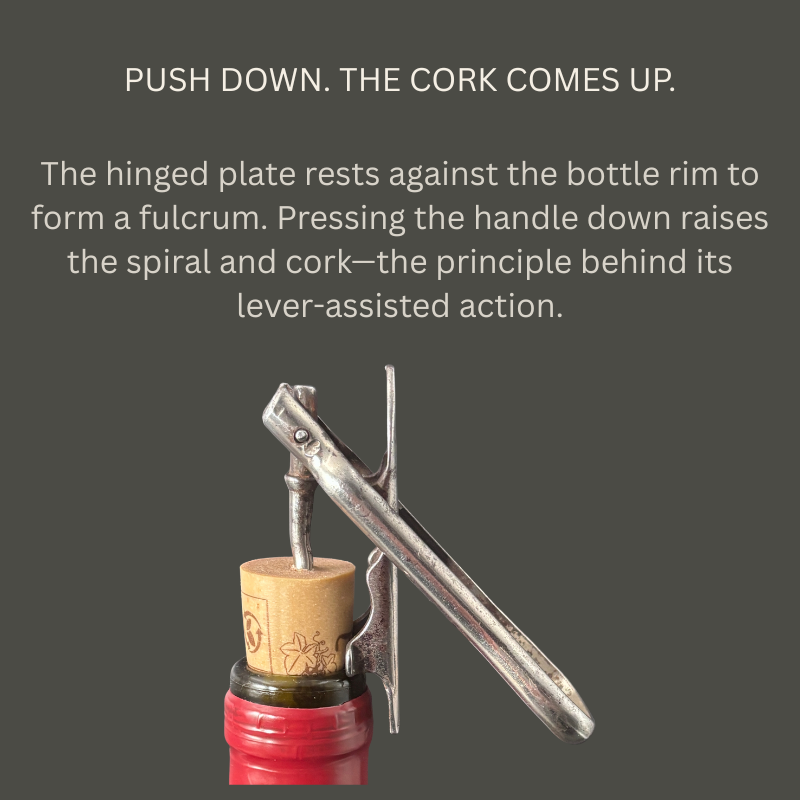 Noyes Universal steel corkscrew engaged in a cork above a red bottle neck, showing the angled handle and hinged fulcrum plate used for lever-assisted extraction.