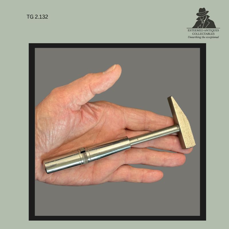Removable metal hammer attachment from the Universal Portable Tool Chest distributed by Allkin & Co. Ltd., Cape Town, South Africa, shown resting in the hand with cylindrical steel handle and rectangular hammer head from a compact travelling tool set.