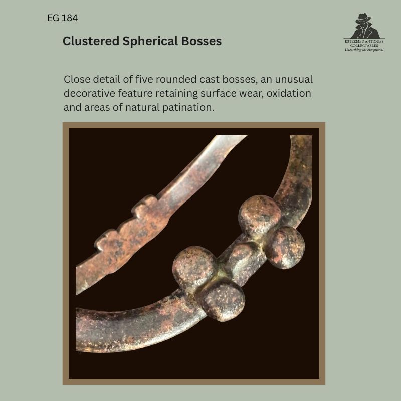 Close detail of clustered spherical bosses on the lost-wax cast copper-alloy Senufo-attributed boat-form anklet EG 184, Côte d’Ivoire, showing five rounded bosses with surface wear, oxidation and natural patination.