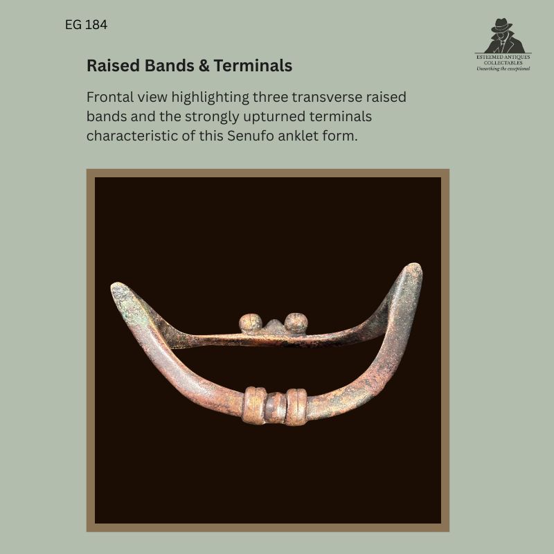 Frontal view of Senufo-attributed boat-form copper-alloy anklet EG 184 from Côte d’Ivoire, showing three raised transverse bands and strongly upturned terminals.