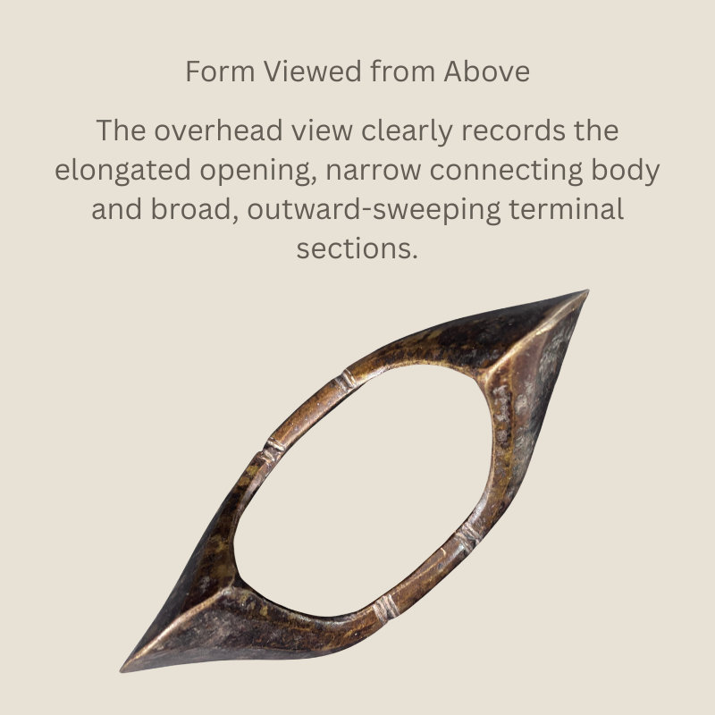 Overhead view of a Senufo-attributed copper-alloy boat-form anklet from Côte d’Ivoire, showing the elongated opening, narrow connecting body and broad outward-sweeping terminals.