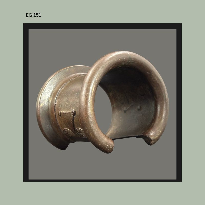 Cast bronze Senufo anklet or bracelet from West Africa with heavy rounded crescent form and incised geometric ornament, shown from the side with dark aged patina, from the Egon Guenther Collection.