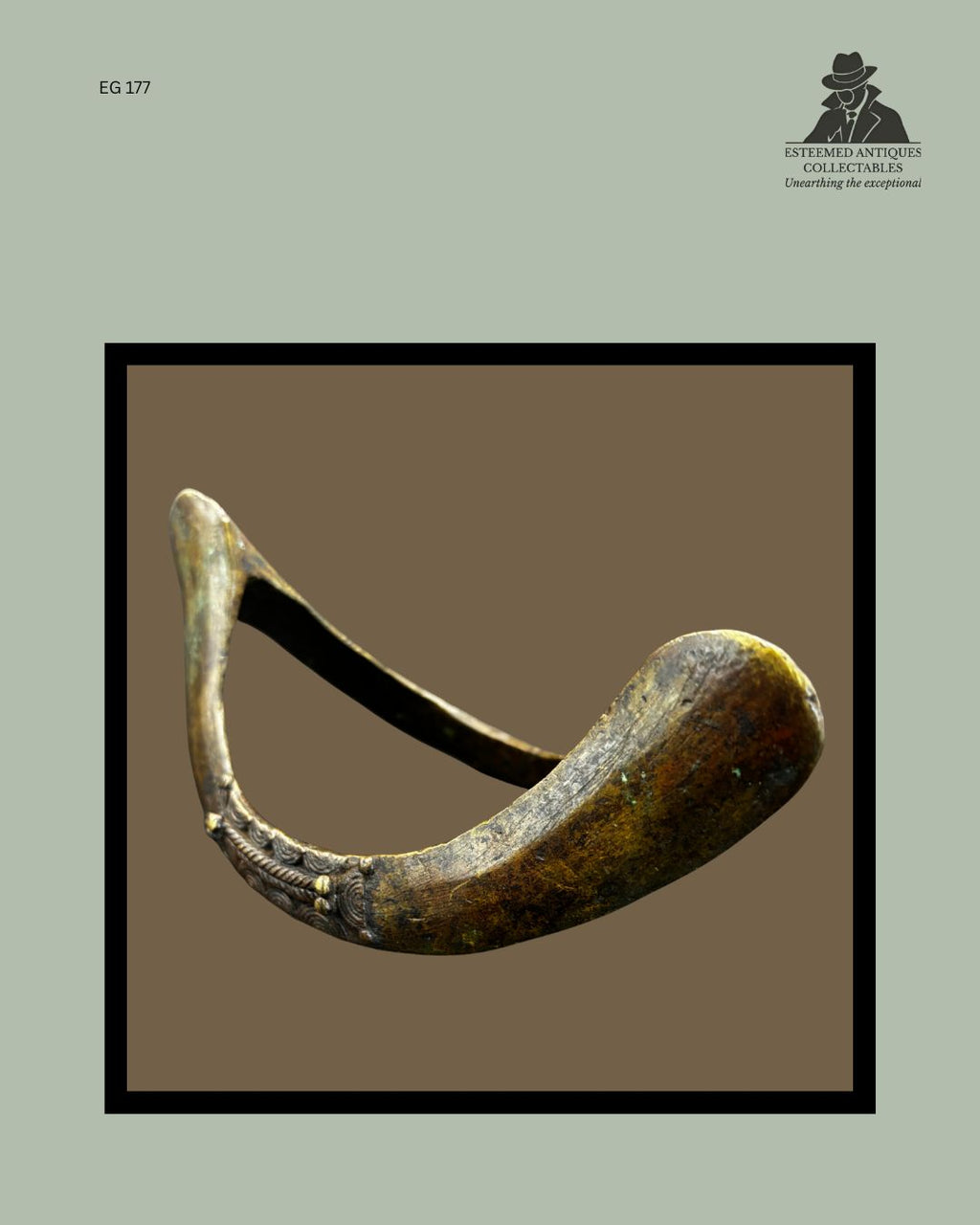 Side view of a Senufo cast bronze prestige anklet from Côte d’Ivoire, showing the curved crescent form, decorative raised banding, dark surface patina, and original ethnographic wear from the Egon Guenther Collection.