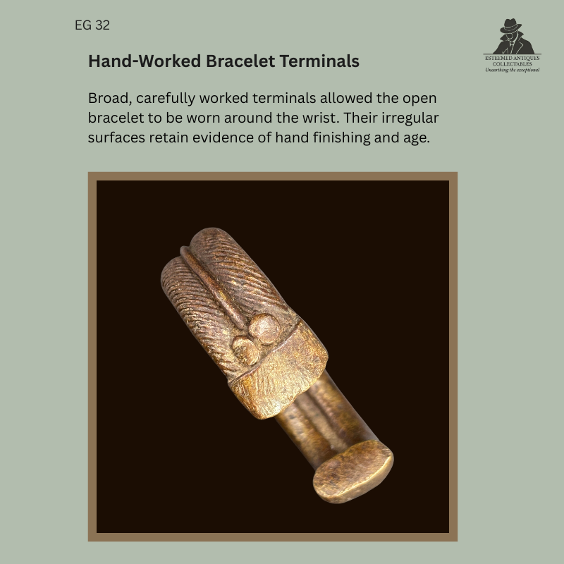 Detail of the broad hand-finished terminals on EG 32, a lost-wax-cast West African zoomorphic protective bracelet attributed to the Senufo, showing incised decoration, irregular surfaces and age-related wear.