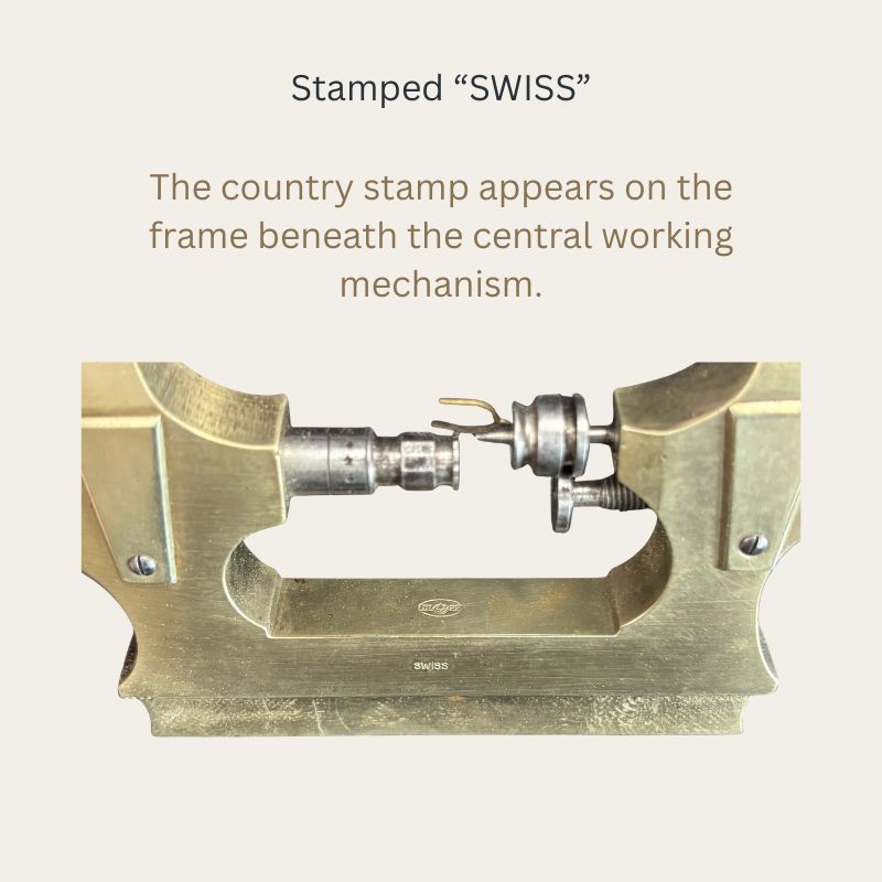 Close view of a Swiss watchmaker’s Jacot pivot lathe, showing the “SWISS” stamp on the brass frame beneath the steel working mechanism.