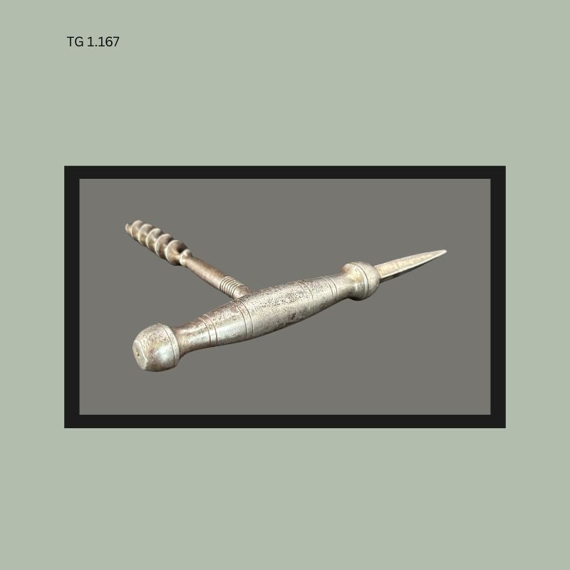 Metal T-handle corkscrew with integrated ice pick spike, featuring a turned cylindrical body and steel worm, likely European manufacture from the early 20th century.