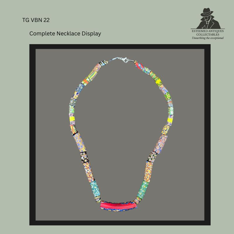 Complete display of a restrung Venetian millefiori glass trade bead necklace comprising assorted antique mosaic glass beads of varied shapes, colours and patterns, finished with a modern clasp and presented in full view for collector documentation.