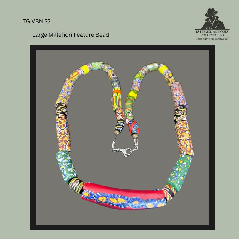 Venetian millefiori glass trade bead necklace featuring a large elongated mosaic feature bead with assorted polychrome millefiori beads, restrung with a modern clasp, shown in full view from the Thomas Guenther Collection.
