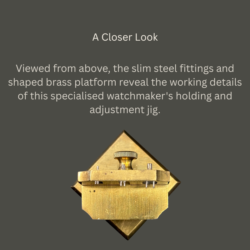 Overhead view of a watchmaker’s brass and steel holding and adjustment jig, showing its shaped platform, crossbar, slender steel fittings and central knurled adjustment screw.
