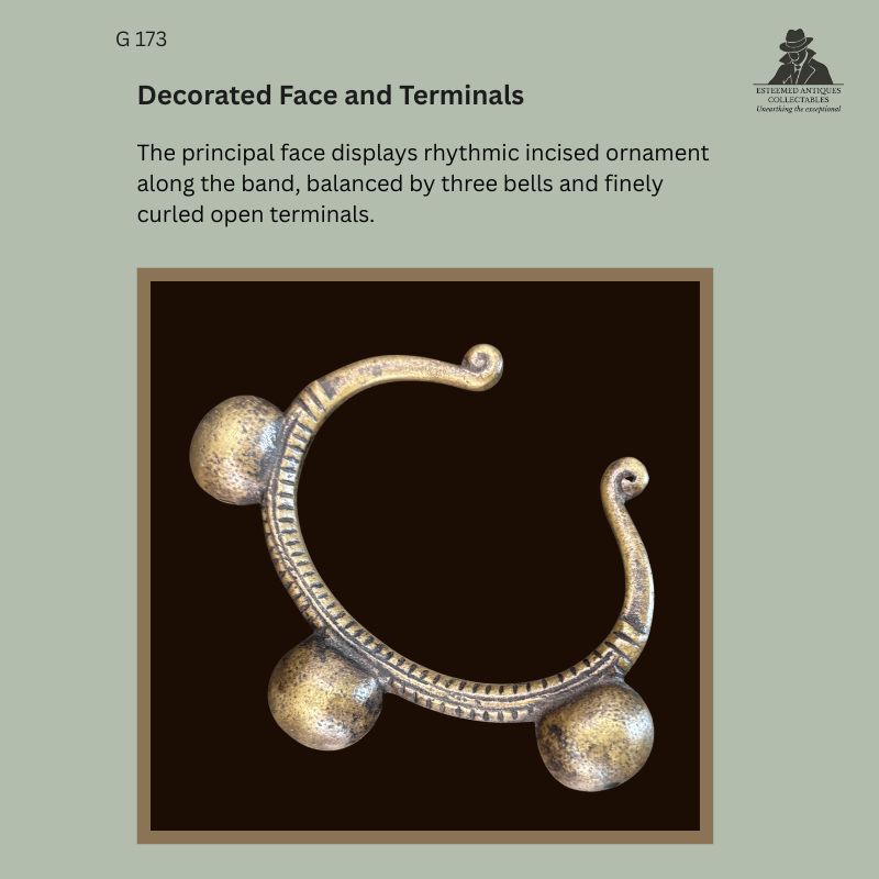 West African cast brass anklet from the Egon Guenther Collection, showing three rounded bells, rhythmic incised decoration along the curved band and finely curled open terminals.