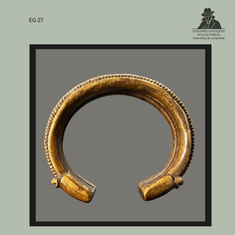Interior view of a West African cast brass currency bracelet with open-ended form, showing the smooth inner surface, thick circular section, and finely notched outer rim, from the Egon Guenther