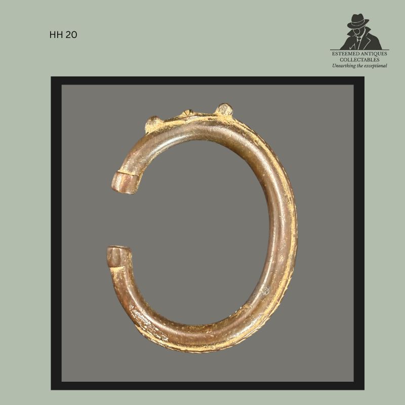 Cast brass open bracelet from West Africa, likely Ghana, formed as a heavy circular cuff with tapered terminals and three small raised decorative projections along the upper rim. Traditional personal ornament and prestige object from the Hans Himmelheber collection, displaying surface wear and aged patina consistent with use.