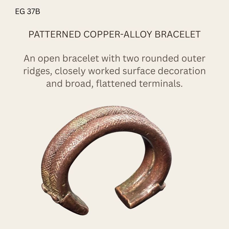 West African copper-alloy penannular bracelet EG 37B, shown obliquely with two rounded outer ridges, crosshatched and angled decoration, broad flattened terminals and a brown patina.
