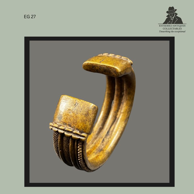 Terminal section of a West African cast brass bracelet showing squared end panels, ribbed decoration, and curved lost-wax construction, from the Egon Guenther Collection by family descent to the Thomas Guenther Collection.