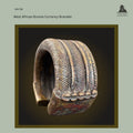 West African cast bronze currency bracelet with deep ribbed decoration and raised terminal border, produced using the lost-wax casting technique, shown in an angled view displaying the heavy crescent form and rich aged patina. Provenance: Hans Himmelheber Collection, later the Egon Guenther Collection, by family descent to the Thomas Guenther Collection.