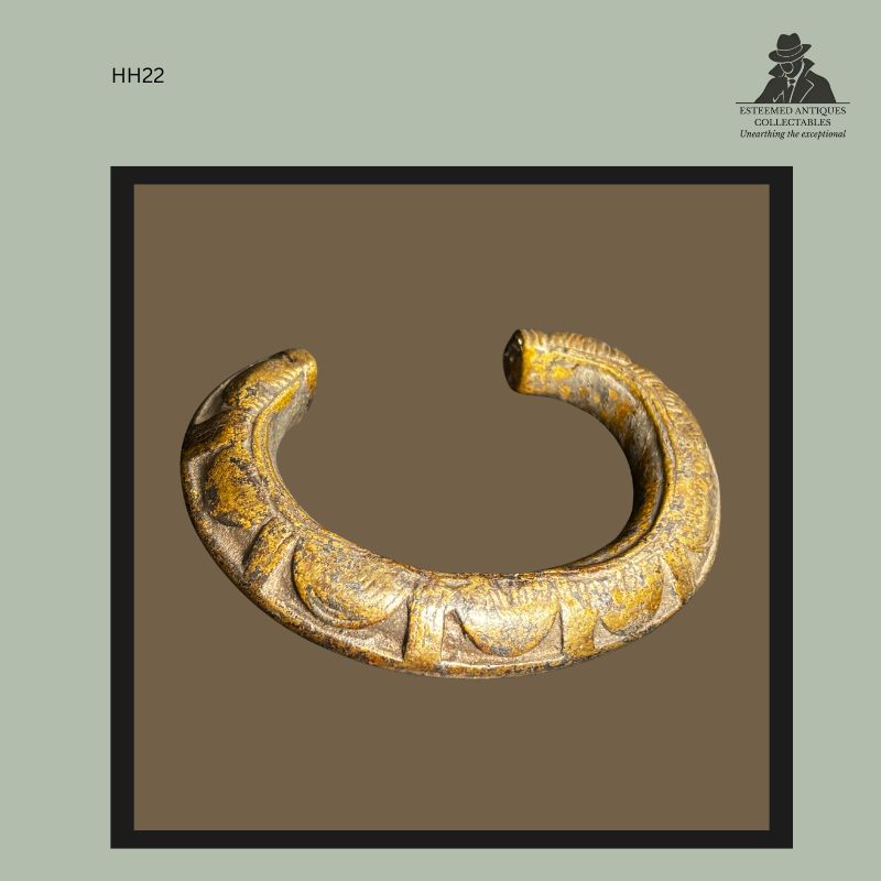 Heavy West African cast brass bracelet with open crescent form and raised geometric decoration, produced by the lost-wax casting technique. The bracelet displays worn surface patina and sculptural relief ornamentation, bearing Hans Himmelheber collection provenance before entering the Egon Guenther and Thomas Guenther collections.