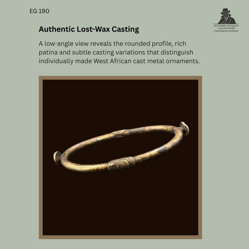 Low-angle view of an early 20th-century West African lost-wax cast copper-brass alloy prestige anklet, probably Gurunsi (Frafra), Northern Ghana, showing its rounded profile, textured central band, rich aged patina, and hand-finished casting characteristics. Provenance: Egon Guenther Collection.