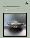 Catalogue panel showing a shallow Zulu-attributed carved wooden ugqoko food dish from KwaZulu-Natal, South Africa, circa 1900–1950, with a dark patinated surface and geometric decoration.
