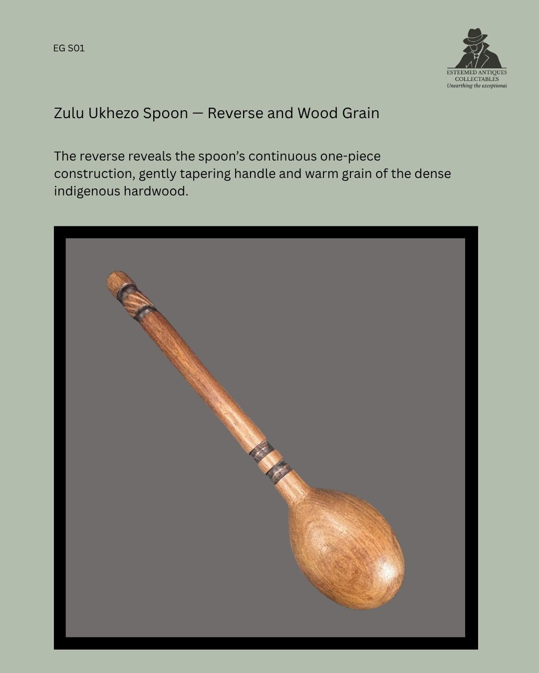 Reverse view of a Zulu ukhezo long-handled serving spoon, showing its hand-carved one-piece hardwood construction, tapering handle, dark incised bands and visible wood grain.